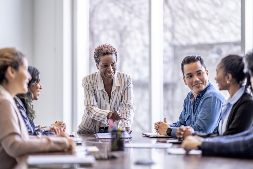 A team meeting around a table discussing a program