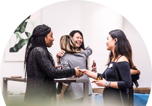 Four colleagues laughing together at a workplace gathering
